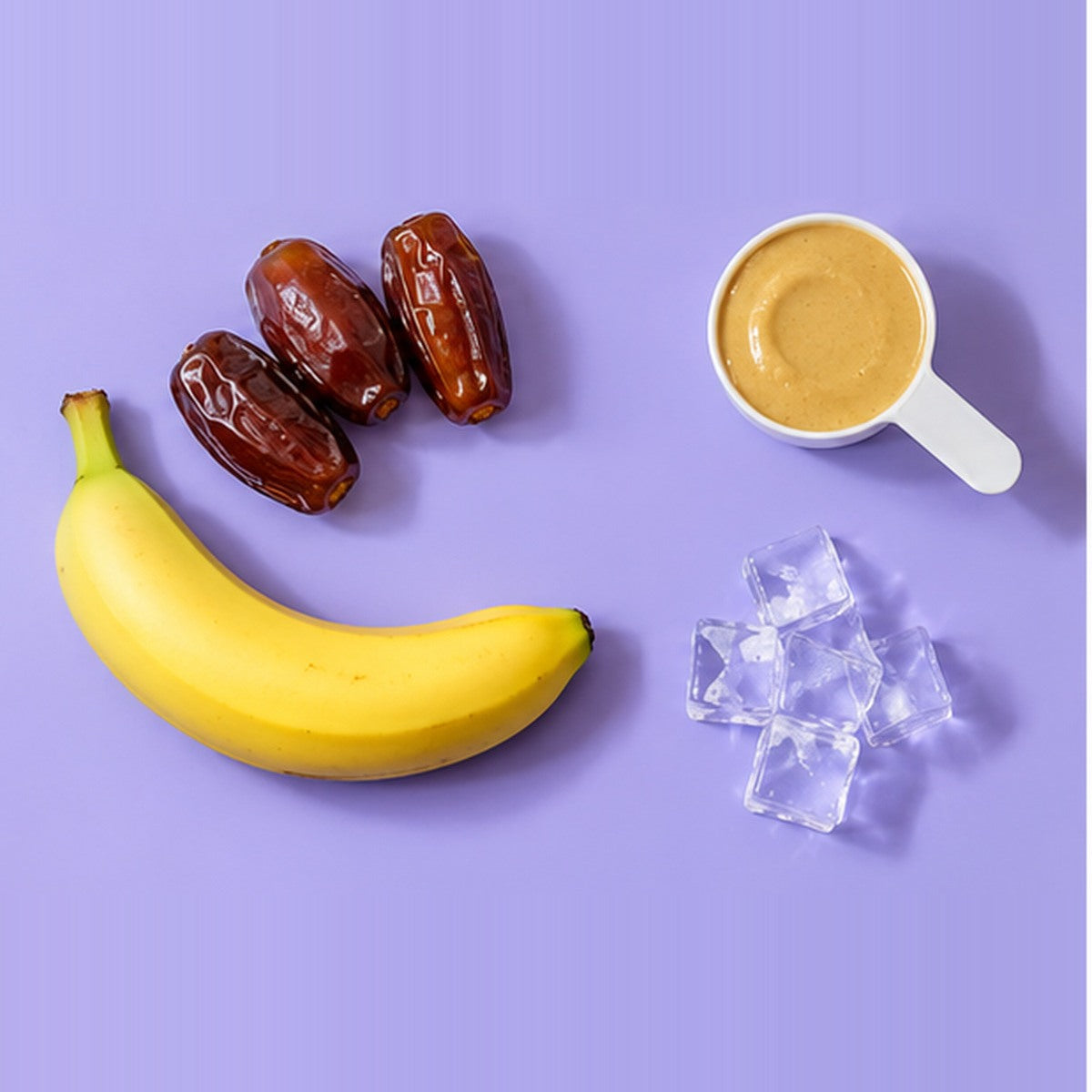 Ingredient flat-lay showing dates, tahini and optional banana on a lavender background