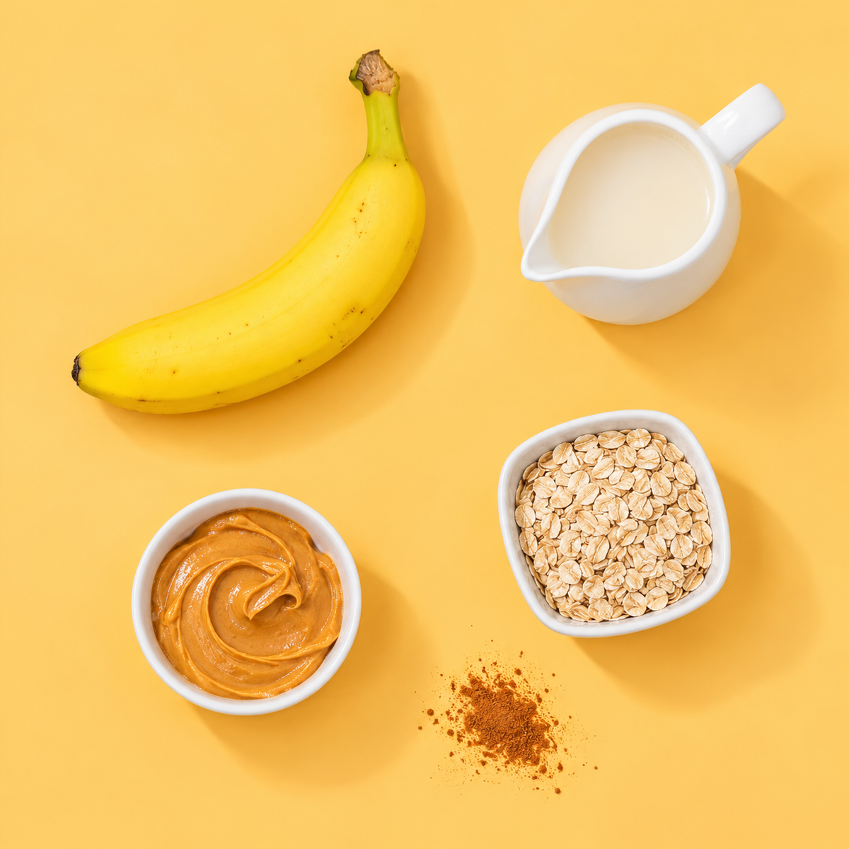 Ingredients for a peanut butter banana smoothie on a golden yellow backdrop