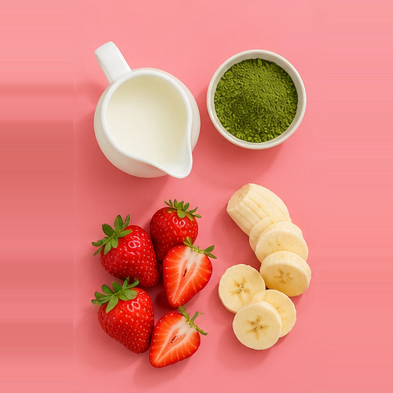 Strawberry matcha smoothie ingredient flat lay with matcha powder, strawberries and milk on a pastel pink background